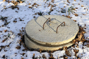 Cement riser and lid on a snowy day