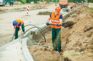 Workers digging dirt on construction site