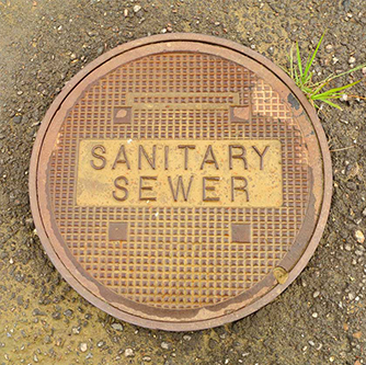 Manhole cover that says sanitary sewer
