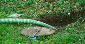 a septic tank being cleaned, the tube is coming out of the ground