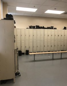 room filled with lockers and boots on the floor and on top of the lockers